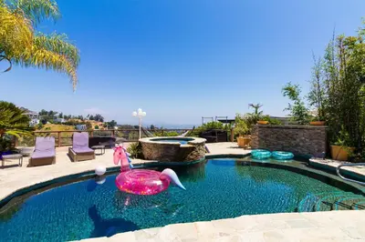 a swimming pool with a pink inflatable duck in the water at Beverly Hills City View Mansion in Los Angeles