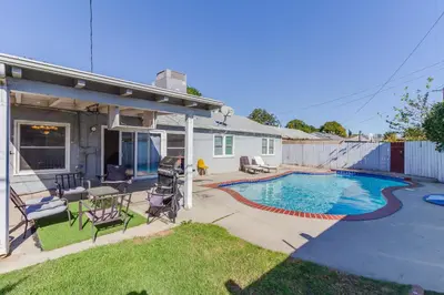 a backyard with a swimming pool and a house at 4 bedroom house with a pool in Reseda