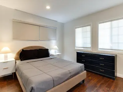 a bedroom with a large bed and two windows at Woodland Hills Zen Modern in Woodland Hills