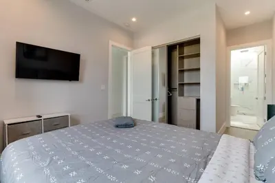 a bedroom with a bed and a flat screen tv at Luxury Modern 4 Bedroom 3 Bathroom Home with Rooftop Deck #1 in Los Angeles