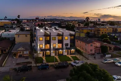 a building in a city with cars parked in a parking lot at Luxury Modern 4 Bedroom 3 Bathroom Home with Rooftop Deck #2 in Los Angeles