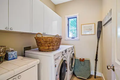 a laundry room with a washing machine with a basket on top at Golden Getaway in Summerland