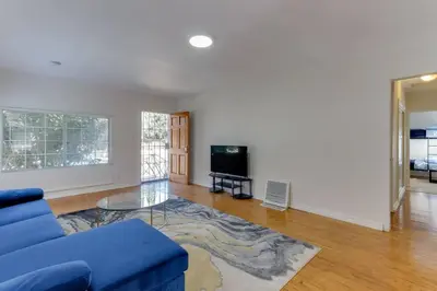 a living room with a blue couch and a glass table at 2 Bedroom Mid-Wilshire Charmer close to Downtown in Los Angeles