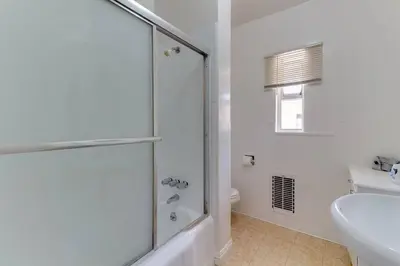 a white bathroom with a shower and a sink at 2 Bedroom Mid-Wilshire Charmer close to Downtown in Los Angeles