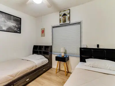 two beds in a room with a window at 3 bedroom Mid-Wilshire Charmer near Downtown in Los Angeles
