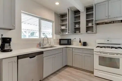 a kitchen with white cabinets and a window at Large 5 bedroom charmer wIth pool in Los Angeles