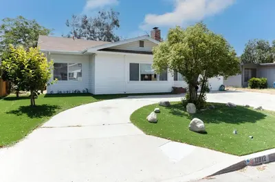a house with rocks on the grass in front of a driveway at Large 5 bedroom charmer wIth pool in Los Angeles