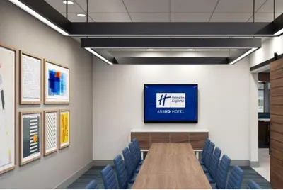 a conference room with a long table and blue chairs at Holiday Inn Express & Suites Hawaiian Gardens by IHG in Hawaiian Gardens
