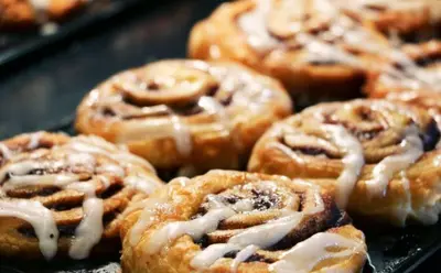a bunch of donuts with icing on a tray at Holiday Inn Express & Suites Hawaiian Gardens by IHG in Hawaiian Gardens