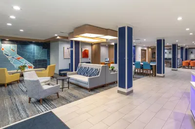 a lobby of a hospital with chairs and tables at Holiday Inn Express & Suites Hawaiian Gardens by IHG in Hawaiian Gardens