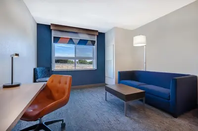 a living room with a blue couch and a table at Holiday Inn Express & Suites Ontario - Chino Hills by IHG in Chino Hills