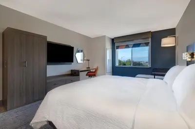 a bedroom with a large white bed and a flat screen tv at Holiday Inn Express & Suites Ontario - Chino Hills by IHG in Chino Hills