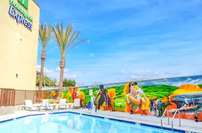 a pool at a resort with a painting on the wall at Holiday Inn Express & Suites Ontario - Chino Hills by IHG in Chino Hills