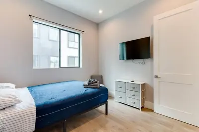 a bedroom with a bed and a flat screen tv at 3 Luxury Modern Homes 12 bedrooms & Rooftop Decks in Los Angeles