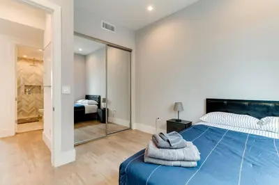a bedroom with a large blue bed and a mirror at 3 Luxury Modern Homes 12 bedrooms & Rooftop Decks in Los Angeles