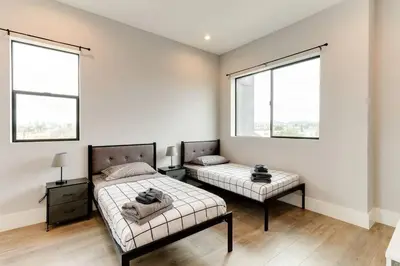 a bedroom with two beds and two windows at 3 Luxury Modern Homes 12 bedrooms & Rooftop Decks in Los Angeles