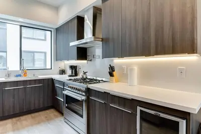 a kitchen with wooden cabinets and a stove top oven at 3 Luxury Modern Homes 12 bedrooms & Rooftop Decks in Los Angeles