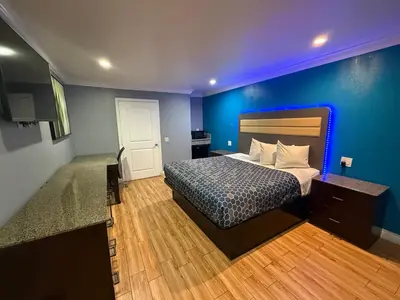 a bedroom with a bed and a blue wall at BELL RESORT MOTEL in Bell