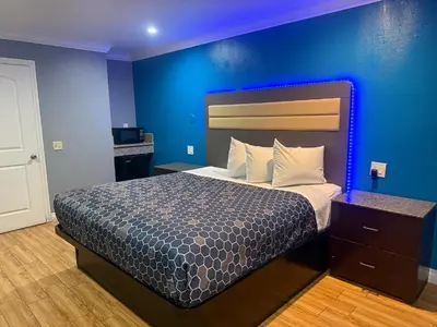 a bedroom with a bed with a blue wall at BELL RESORT MOTEL in Bell