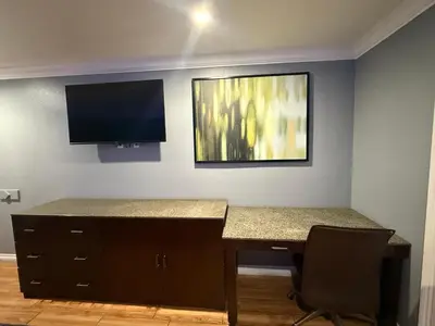 a room with a desk and a television on the wall at BELL RESORT MOTEL in Bell