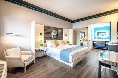 a bedroom with a bed and a desk and a chair at Aspire Inn Studios & Spas in Bellflower