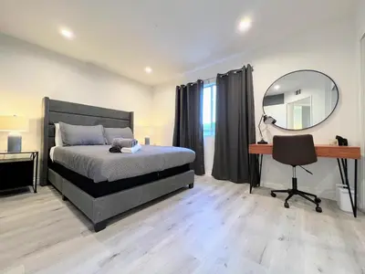 a bedroom with a bed and a desk and a mirror at Hollywood Black Habitat in Los Angeles