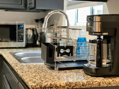 a kitchen counter with a coffee maker next to a sink at Hollywood Black Habitat in Los Angeles