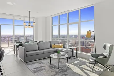 a living room with a couch and chairs and windows at Level Los Angeles - Downtown Flower in Los Angeles