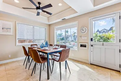 a dining room with a table and chairs and a clock at Rivo of Dreams in Long Beach