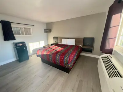a bedroom with a bed with a red blanket at Keystone Motel in Norwalk
