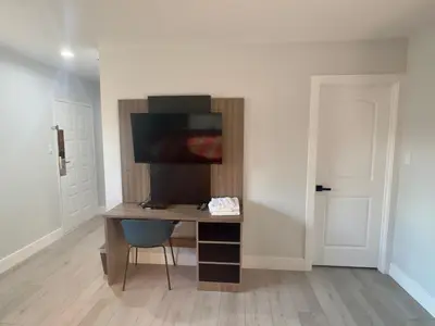 a desk with a monitor and a chair in a room at Keystone Motel in Norwalk