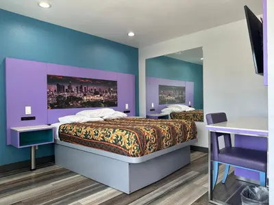 a bedroom with two beds and a mirror at Fountain Inn Motel - Alhambra, Los Angeles in Alhambra