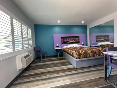 a bedroom with two beds and blue walls at Fountain Inn Motel - Alhambra, Los Angeles in Alhambra