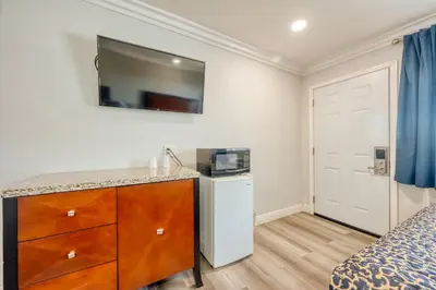 a bedroom with a dresser and a tv on the wall at ERTH INN by AGA- Mojave in Mojave