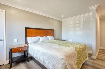 a bedroom with a large bed with a wooden headboard at ERTH INN by AGA- Mojave in Mojave