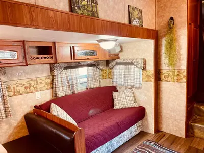 a red couch in a small room in an rv at Vintage RV Creekside Nature Retreat near Ojai next to Swim Holes Hike in Santa Paula