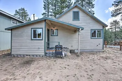 a small house with a grill in front of it at Walk to Big Bear Lake Cozy Cabin with Deck in Big Bear Lake