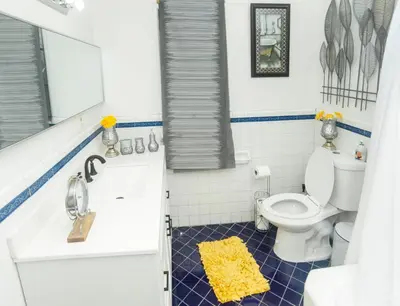 a bathroom with a toilet and a yellow rug at Manuel Y Sonia-La casa de los Angeles in Long Beach