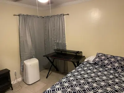 a bedroom with a bed and a table next to a window at Sky Fresh Home Stay in Apple Valley