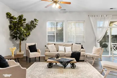 a living room with a couch and chairs and a ceiling fan at NorthWest Farmhouse in Bakersfield