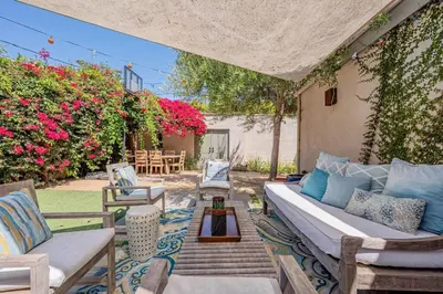 a patio with a couch and chairs and flowers at Secluded 4BR Spanish Oasis in the Heart of LA in Los Angeles
