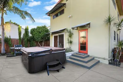 a barbecue outside of a house with a red door at Beach Villa * Hot Tub * Steps to Beach in Long Beach