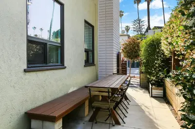 a wooden bench sitting on the side of a building at Beach Villa * Hot Tub * Steps to Beach in Long Beach