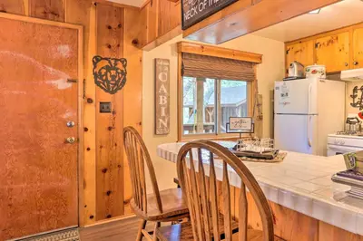 a kitchen with a table and chairs and a refrigerator at Wrightwood Cabin with Cozy Interior! in Wrightwood