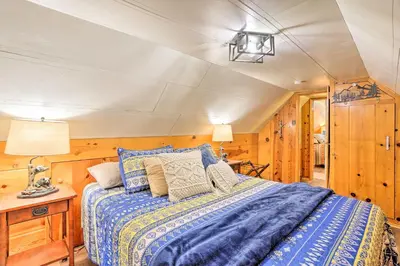 a bedroom with a bed in a room with wooden walls at Wrightwood Cabin with Cozy Interior! in Wrightwood