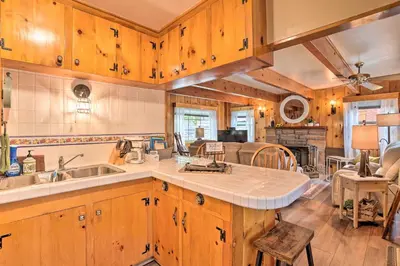 a kitchen with wooden cabinets and a counter top at Wrightwood Cabin with Cozy Interior! in Wrightwood