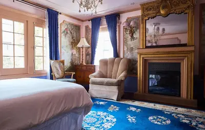 a bedroom with a bed and a fireplace and a chair at Hollywood Home in Los Angeles