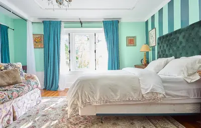 a bedroom with blue walls and a bed and a window at Hollywood Home in Los Angeles