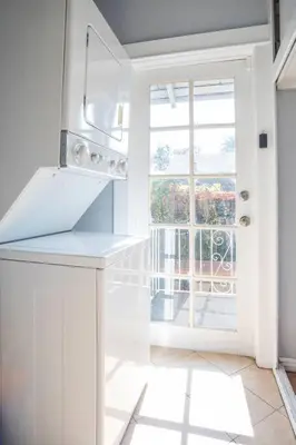 a white kitchen with a window and a stove top oven at Hollywood house with parking - walk to attractions in Los Angeles