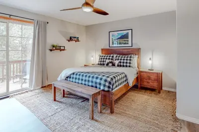 a bedroom with a bed with a table and a window at Sequoia Serenity in Lake Arrowhead